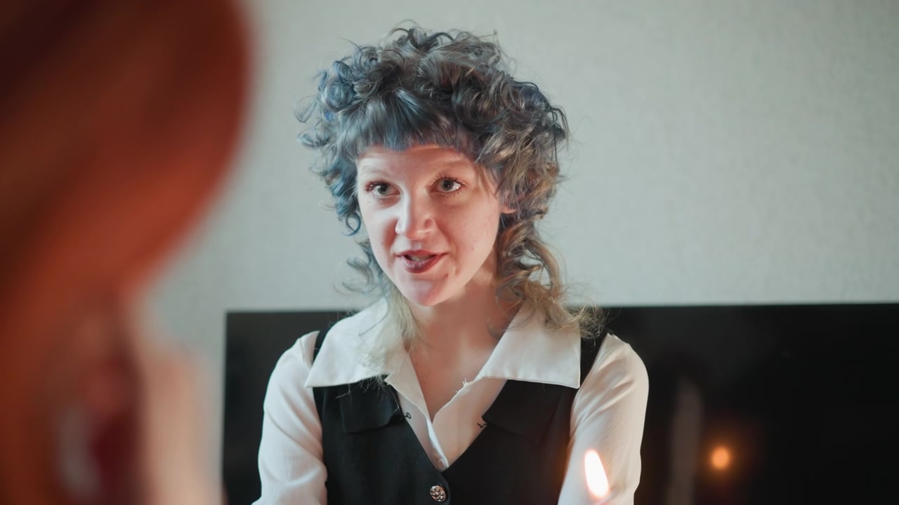 Kaukasisk kvinne spår ved stearinlys, alvorlig blikk og dempet profilbilde, silhuett av rødhåret klient i forgrunnen, stille hviskende spådom og rituell energi, flimrende flamme kaster dramatisk lys.
