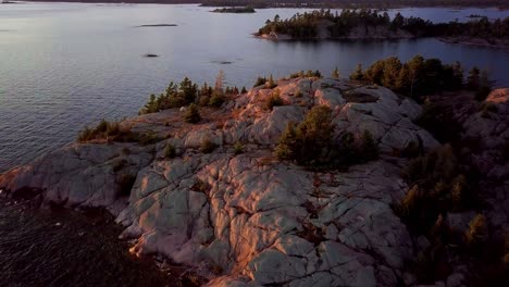 Pequeña-Carpa-Blanca-En-Una-Isla-Rocosa-En-Un-Lago-Azul,-Revelación-épica-De-Drones,-Gran-Angular-Aéreo