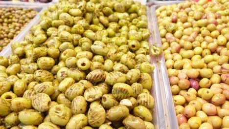 primer plano de aceitunas verdes y aceitunas amarillas en un mercado