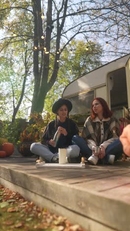 friends enjoying autumn day by camper