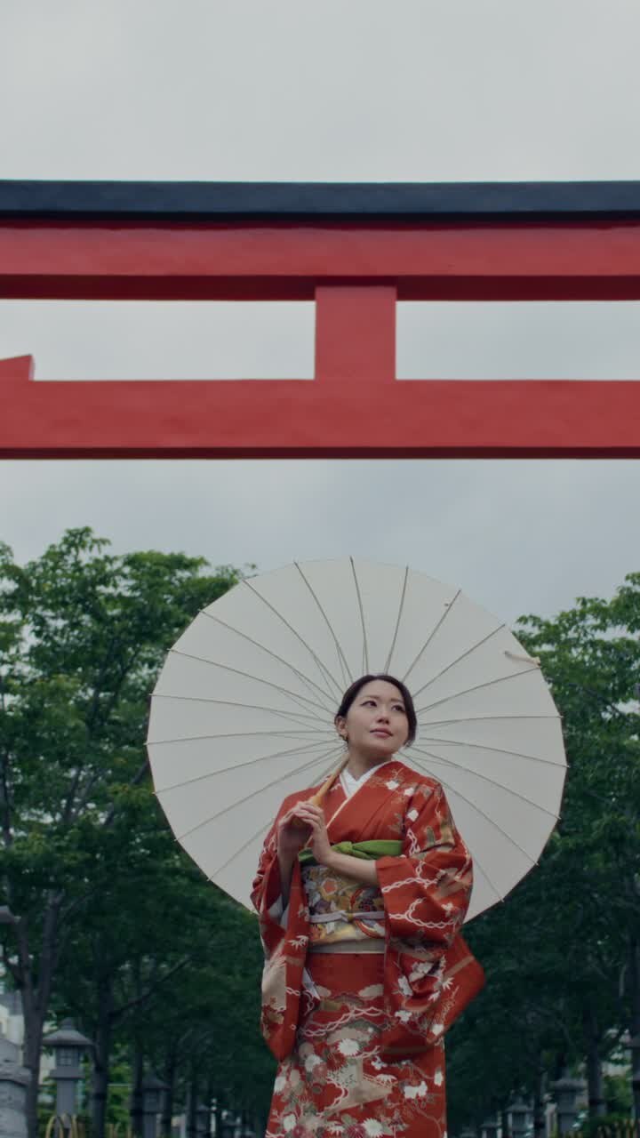Donna in kimono a un portale torii