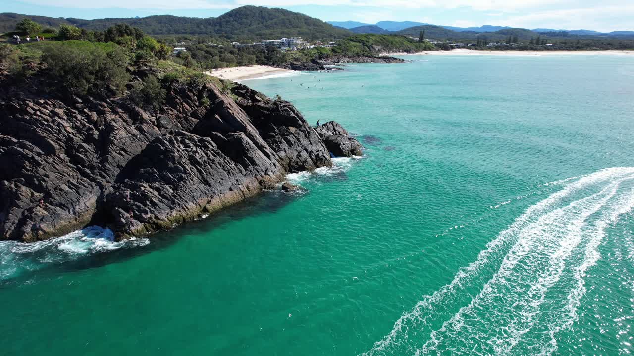 olas espumosas salpicando en el promontorio rocoso en la playa de cabarita, tweed shire, bogangar, ríos del norte, nueva gales del sur, australia tiro aéreo de retirada