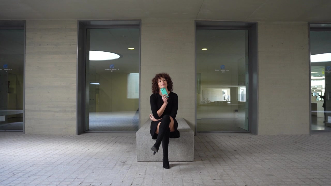 Una donna pensierosa e contemplativa posizionata in uno spazio architettonico moderno ed elegante.