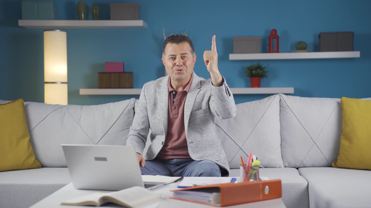 가정 사무직 노동자 남자가 카메라를 바라보며 아이디어를 떠올립니다.