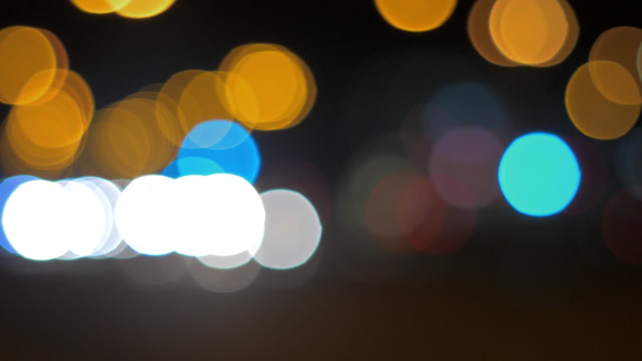 semáforos de coche bokeh en movimiento en la ciudad durante la noche