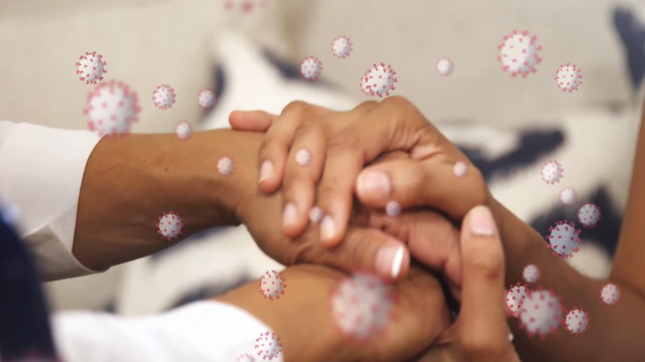 animação de células macro coronavirus covid-19 espalhando-se sobre mãos de raça mista segurando umas às outras