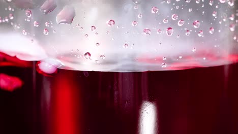 smoke rises from a red liquid experiment