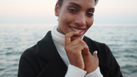 smiling african american girl sending air kiss to camera.