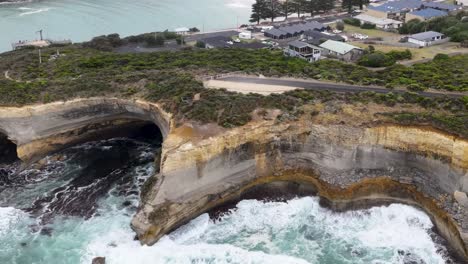 Drone captures rugged cliffs and crashing waves along the coastline, showcasing dynamic natural formations and vibrant sea colors.