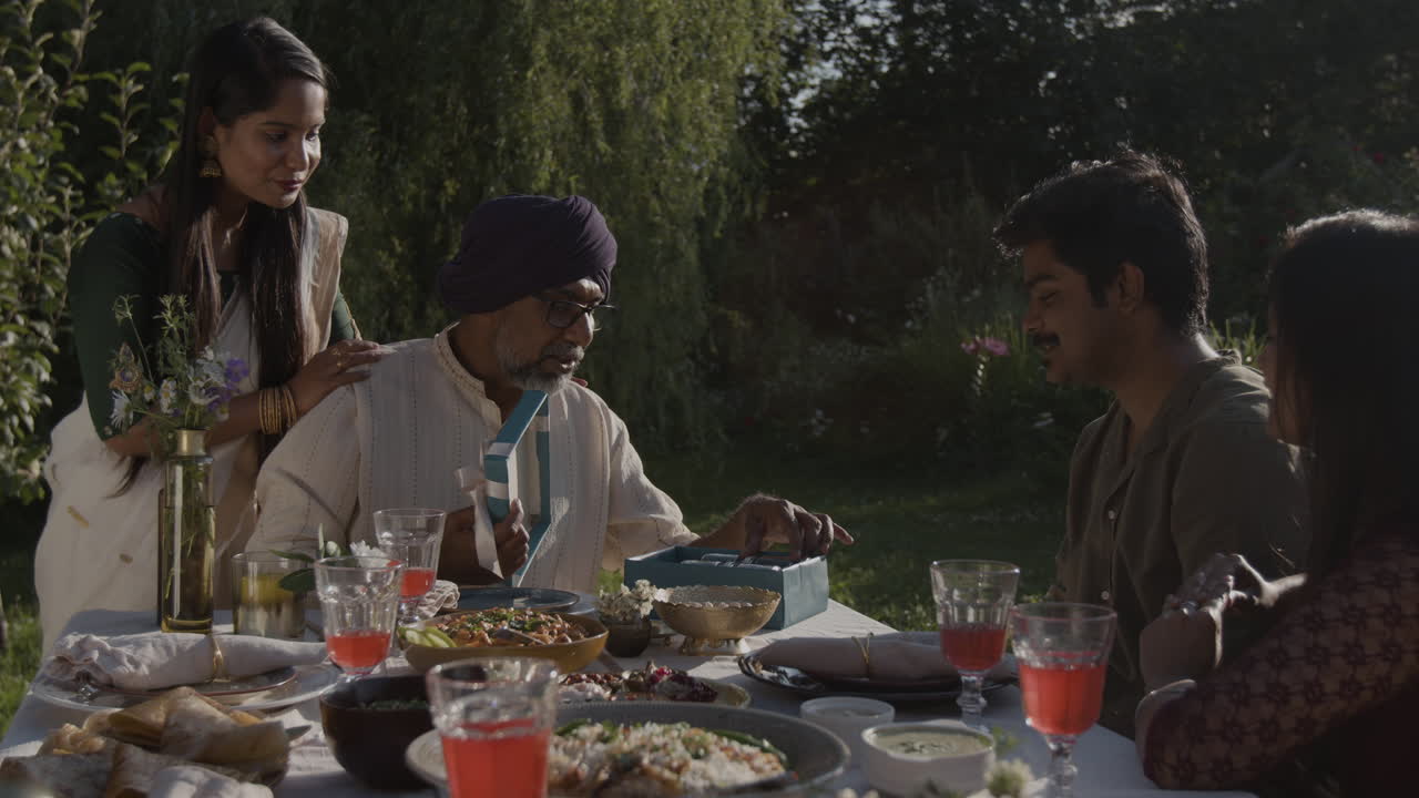 Multi-generational Indian Family Gathering Outdoors for a Meal and Celebration