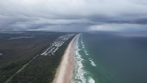 casuarina beach and town seen from cabarita beach - distant rain and dark clouds in nsw, australia