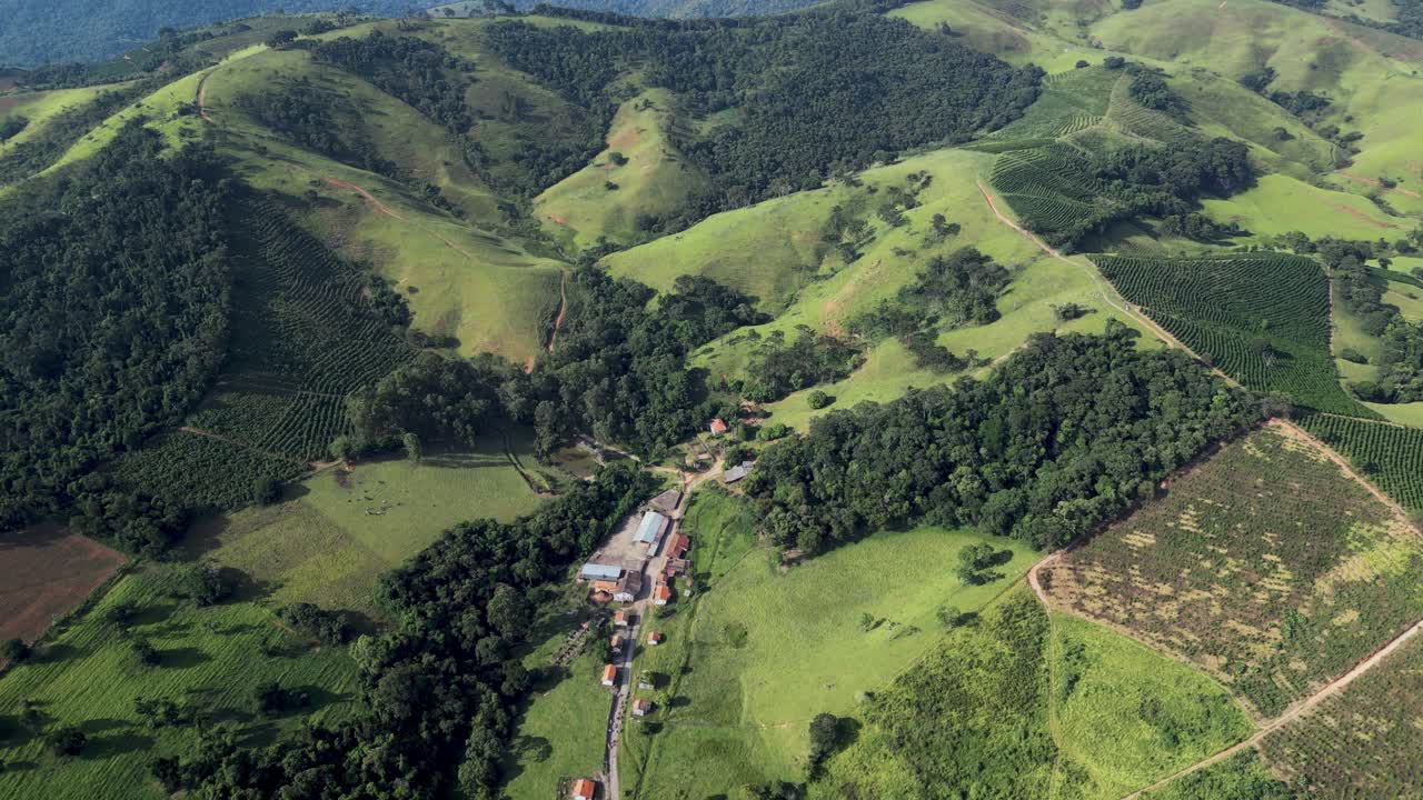 aerial view looking downa small remote village in the middle of the Serra da Mantiqueira, southern Minas Gerais, a green area with agriculture and mountain bike trails.