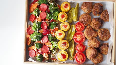 verduras asadas variadas y albóndigas en una bandeja de madera