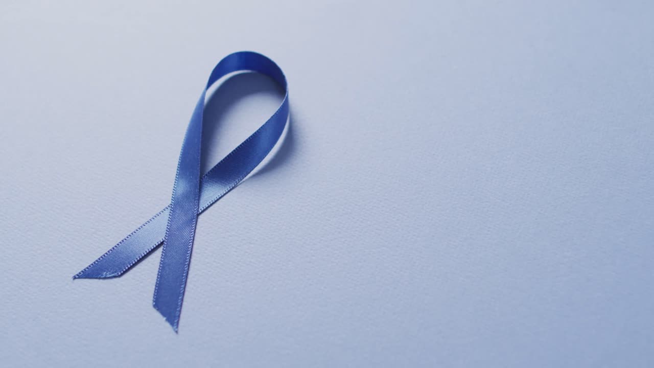 밝은 파란색 배경에 있는 어두운 파란색 대장암 리본의 비디오