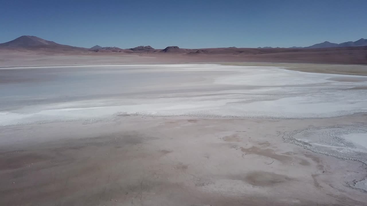 Bolivia's captivating landscape, aerial of vast white salt surface desert that extends to the distant horizons