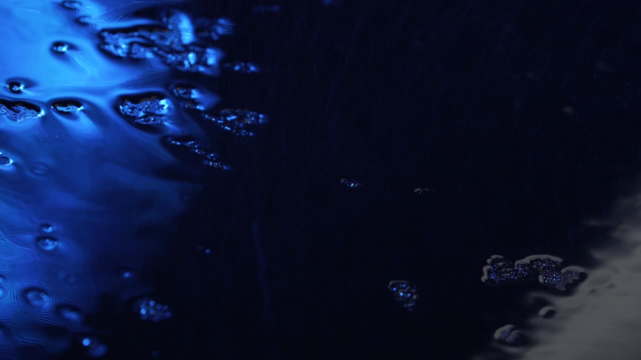 стрельба капель жидкости на темно-синее стекло