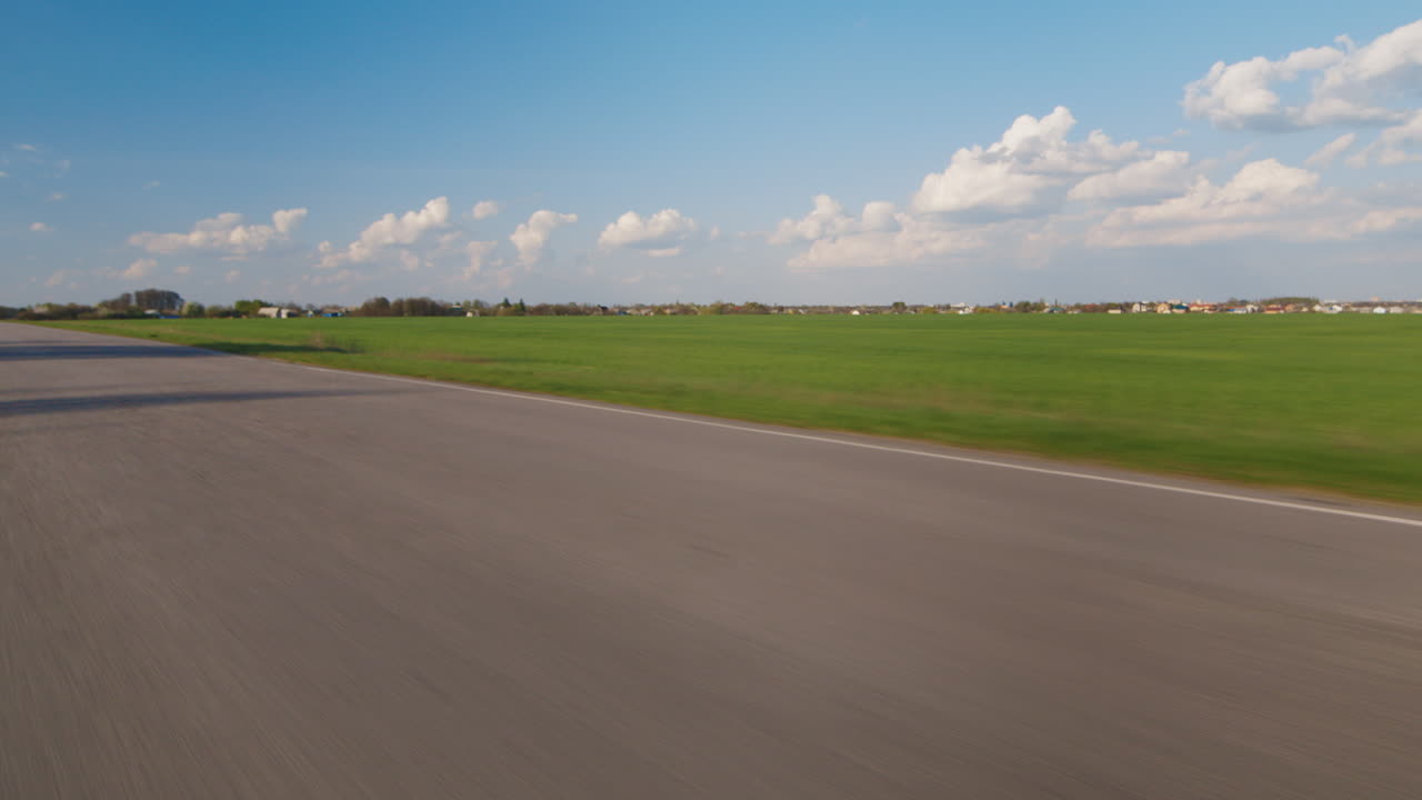 여행 꿈 - 바이커는 푸른 하늘과 푸른 들판을 배경으로 시골길을 따라 탄다