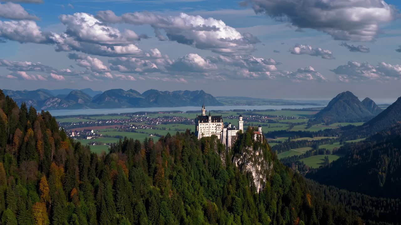 The video showcases a majestic castle nestled in lush green hills, with sweeping views of distant