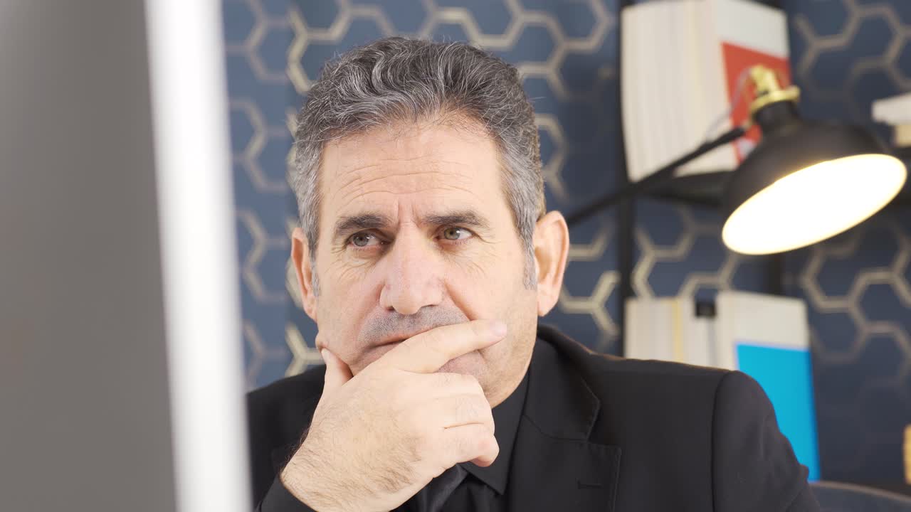 el hombre de negocios está mirando la computadora de una manera seria y disciplinada y analizando el curso de los negocios.