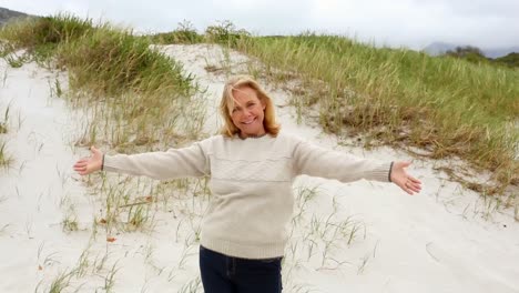Smiling-retired-woman-standing-on-the-beach