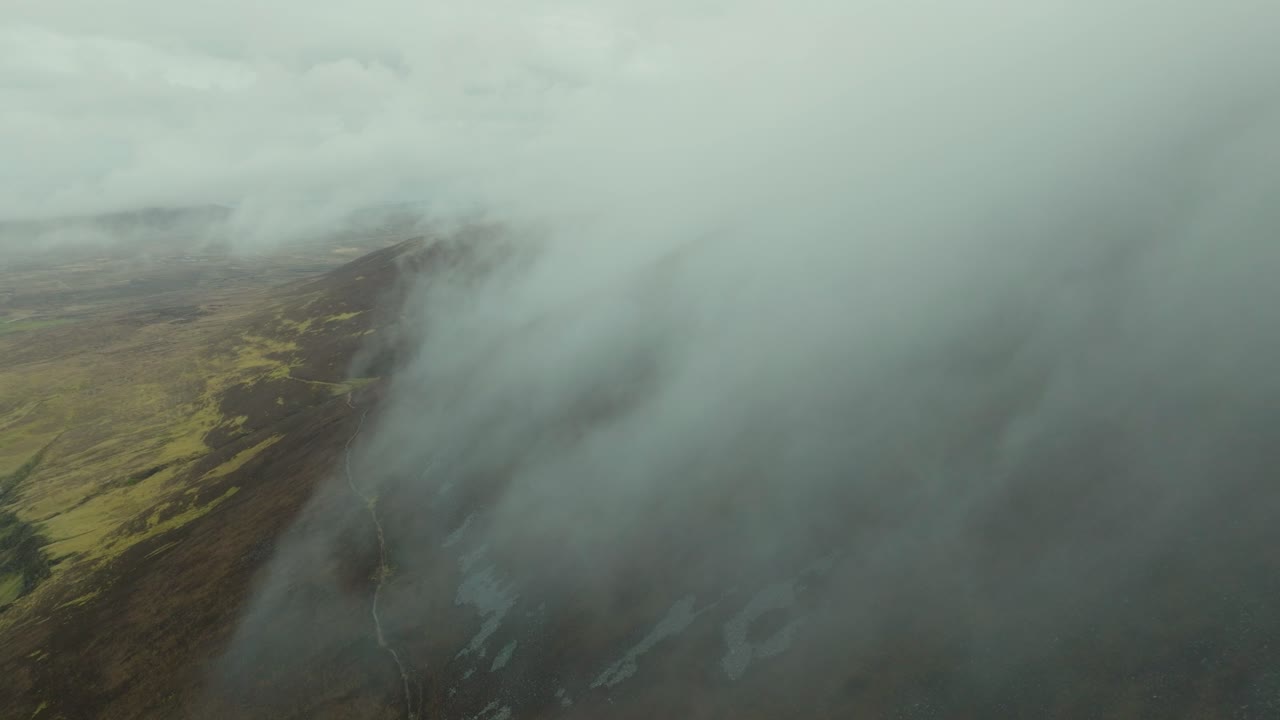 avión no tripulado volando en las nubes bajas sobre los acantilados de la isla de achill