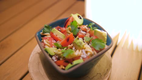 Deliciosa-Ensalada-De-Pasta-Fusilli-En-Un-Bol-Mezclada-Con-Tomate,-Aguacate-Y-Nueces