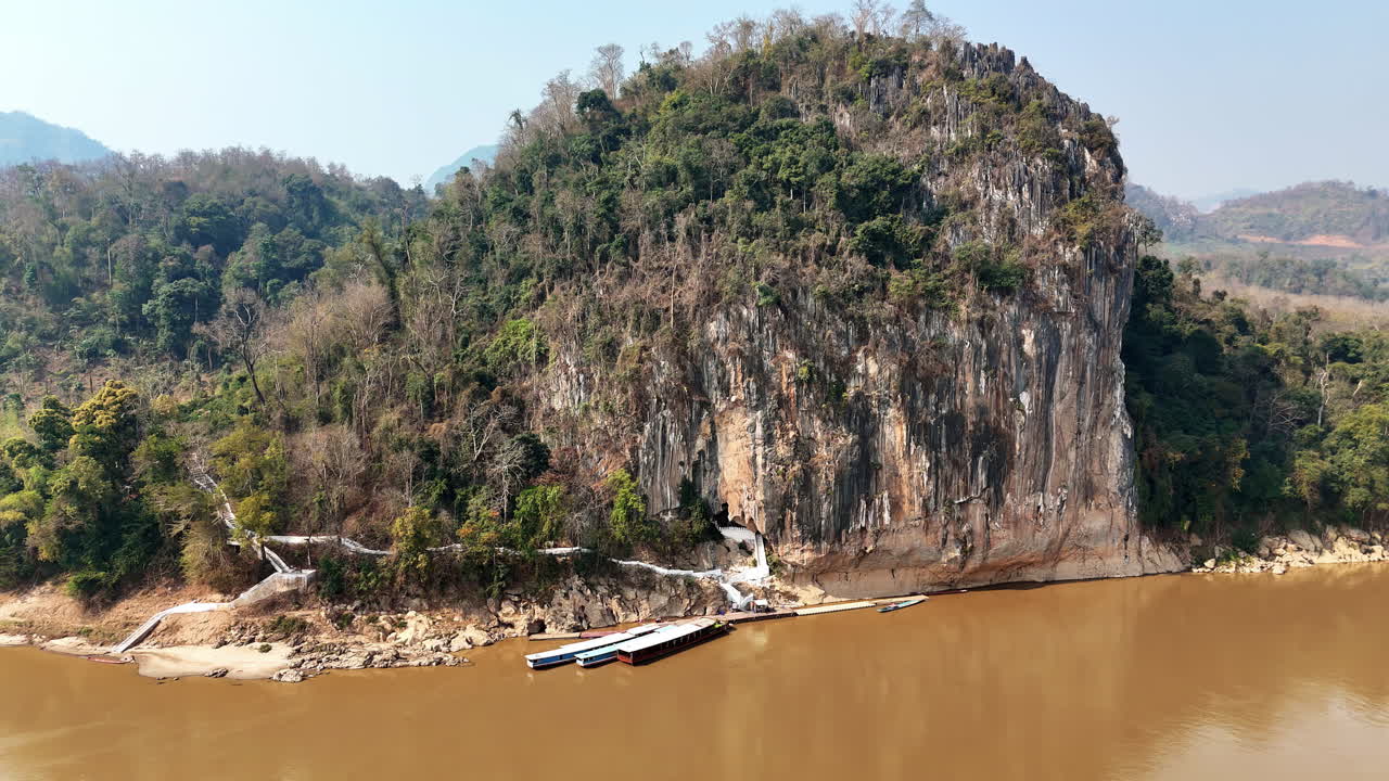 Vista aerea con drone dell'acqua che scorre su rocce calcaree in una piscina naturale turchese presso le cascate di Kuang Si, una delle cascate più famose del Laos.