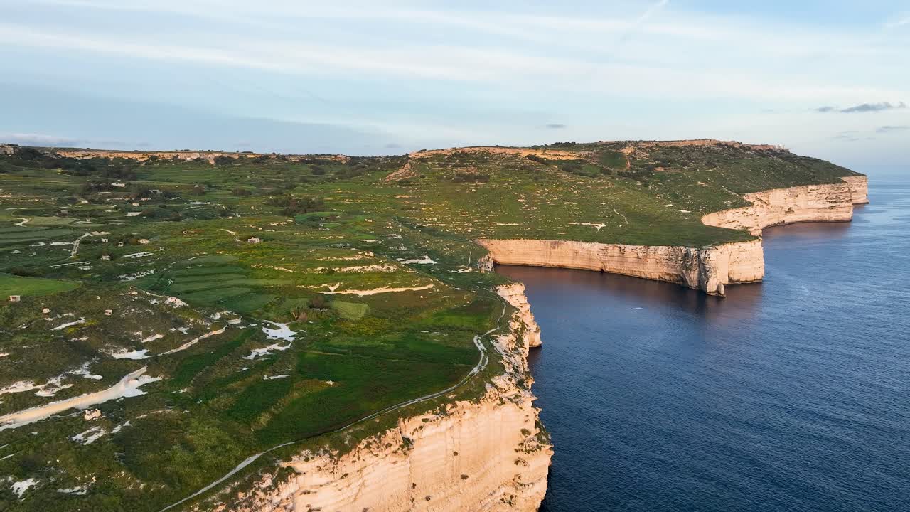 Witness the contrast of sun-washed limestone and vibrant fields atop Malta’s western cliffs, with winding paths and dramatic seascapes in every frame.