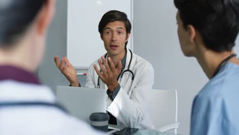 young doctors consulting together sitting at table 4k