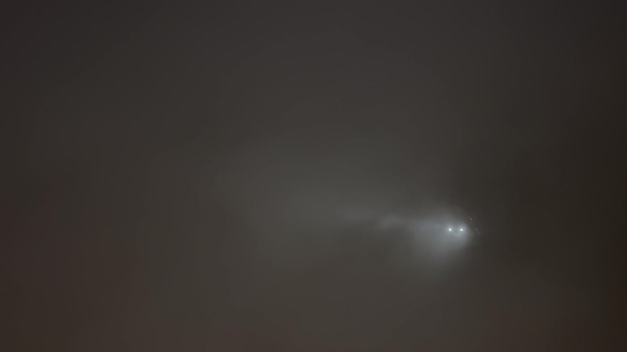 안개 속에서 비행기가 불을 켜고 구름 한가운데 하늘을 지나는 순간