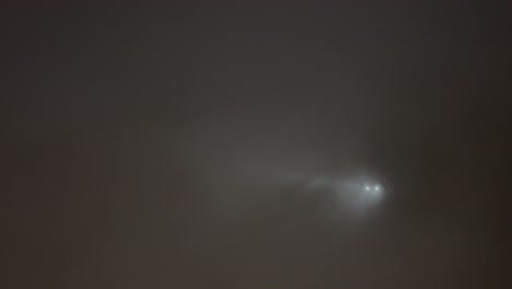 el momento en que un avion paso por el cielo en medio de las nubes con sus luces encendidas en la niebla