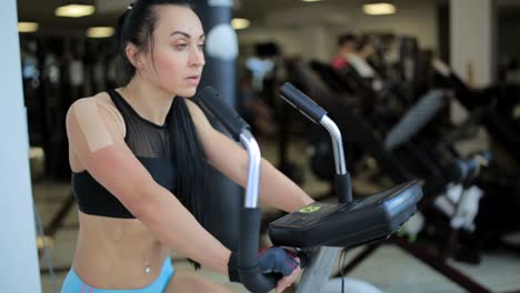 active beautiful girl working hard on a stationary bike indoors active beautiful girl working hard on a stationary bike indoors caucasian sportswoman looking cheerful while burning calories in gym high quality footage
