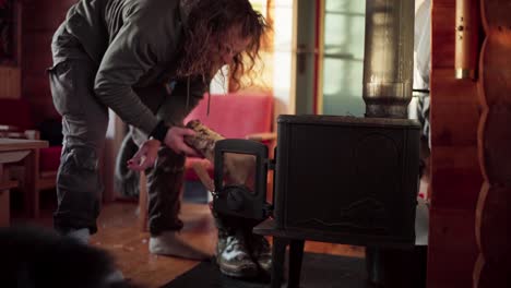 The-Man-is-Loading-Firewood-Into-a-Heater-to-Keep-Warm-During-the-Winter-in-Bessaker,-Trondelag-County,-Norway---Close-Up