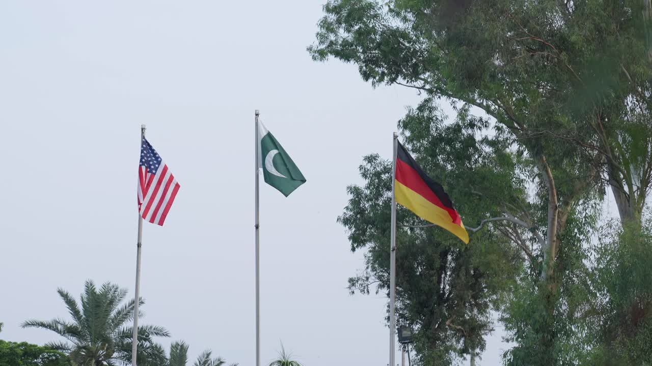 Usa, Pakistan And Germany Flags Flying At Full Mast In Unity And Pride On A Flag Pole.