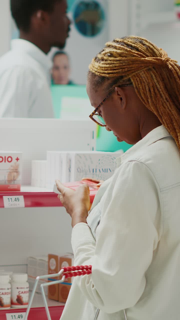 Vertical video: Young woman checking box of pills in medical shop