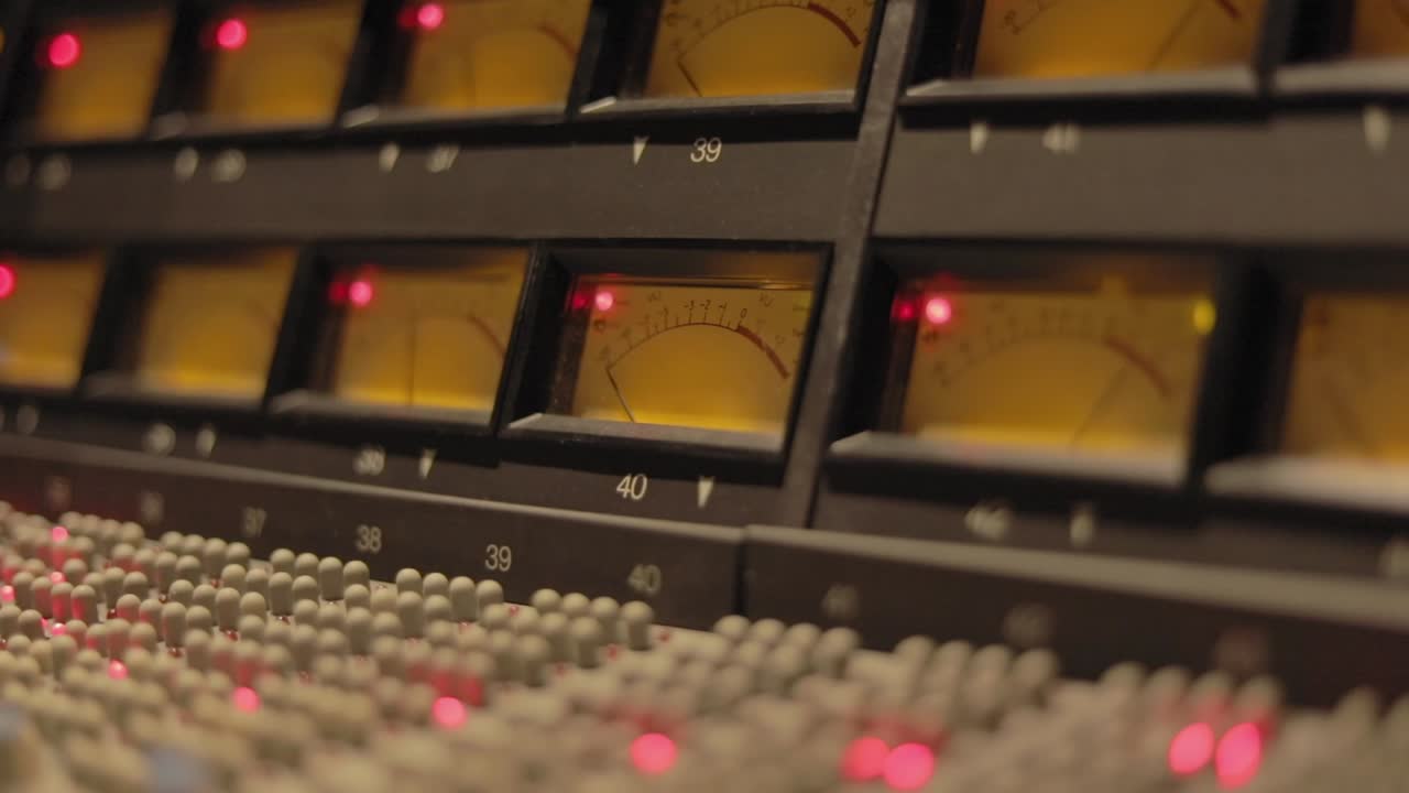 스튜디오 내부의 페이더, 조정 노브 및 vu 미터가 있는 전문 전자 오디오 믹싱 콘솔