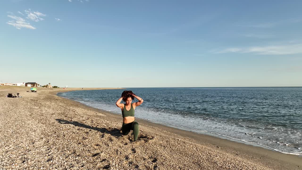 Woman performing yoga asana sequence on beach
