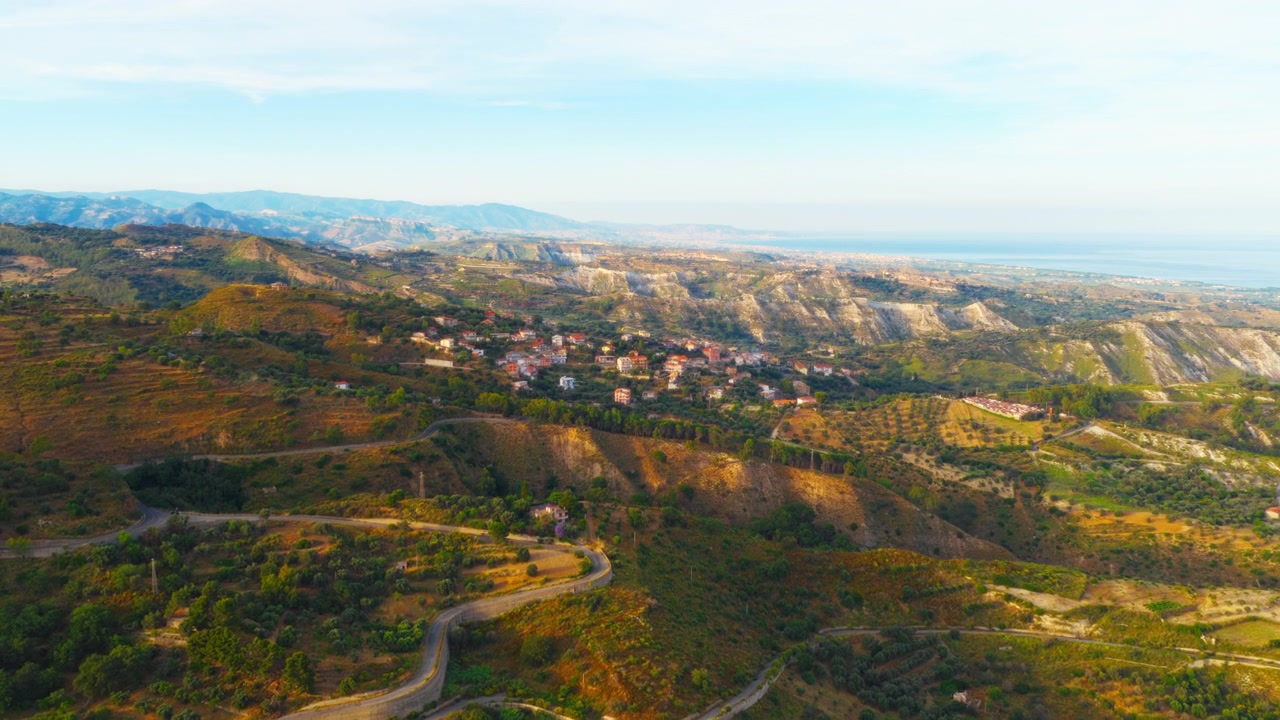 Vista aerea di un borgo rurale nella campagna italiana con una costa in lontananza