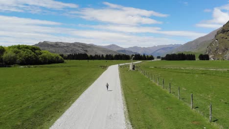 drone, aerial views of car driving through mountains in new zealand