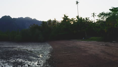 Sun-rising-above-mountains-and-jungle-on-tropical-beach-at-low-tide