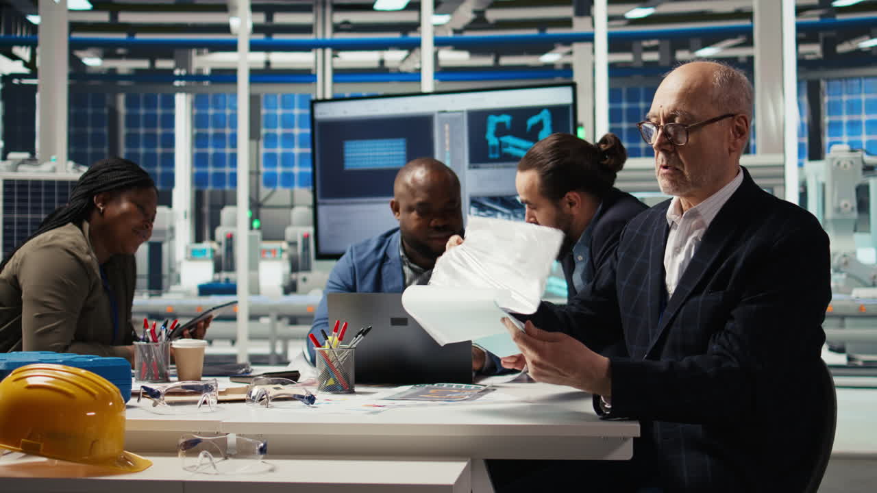 Industrial Plant Senior Manager Looking Over Paperwork Files