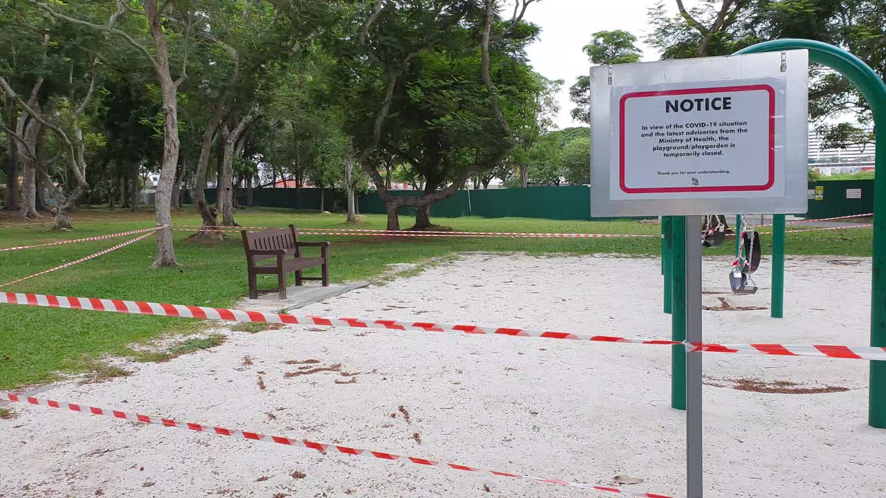 Children's playground with barrier tape and warning signs during Covid-19 lockdown in a public park in Singapore, Asia