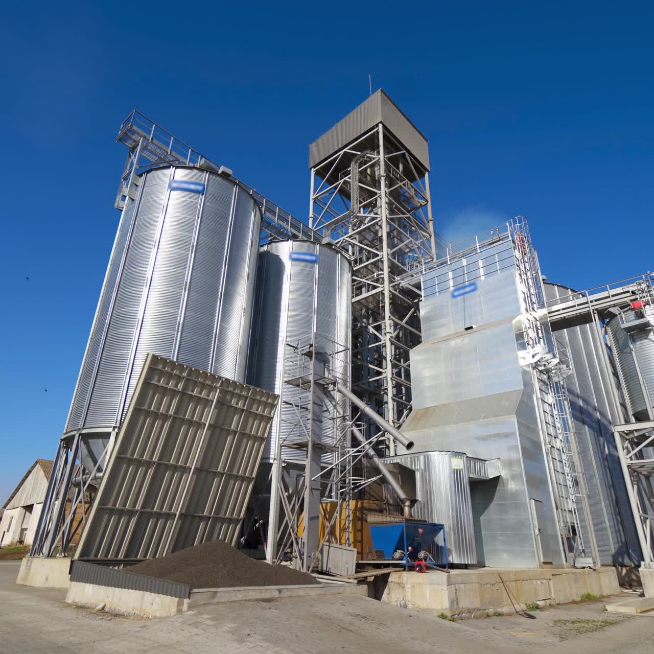 Panoramic view of a modern warehouse. New industrial factory on blue sky background in the countryside. Metal storage granary for agribusiness at sunlight