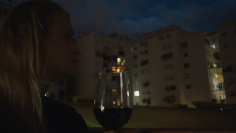 Una-Mujer-Joven-Sostiene-Una-Copa-De-Vino-En-Un-Balcón