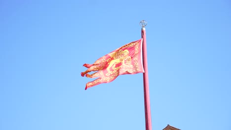 Fuerte-Viento-Ondeando-La-Bandera-Roja-Veneciana-Con-Un-León-Alado-En-Un-Día-Soleado