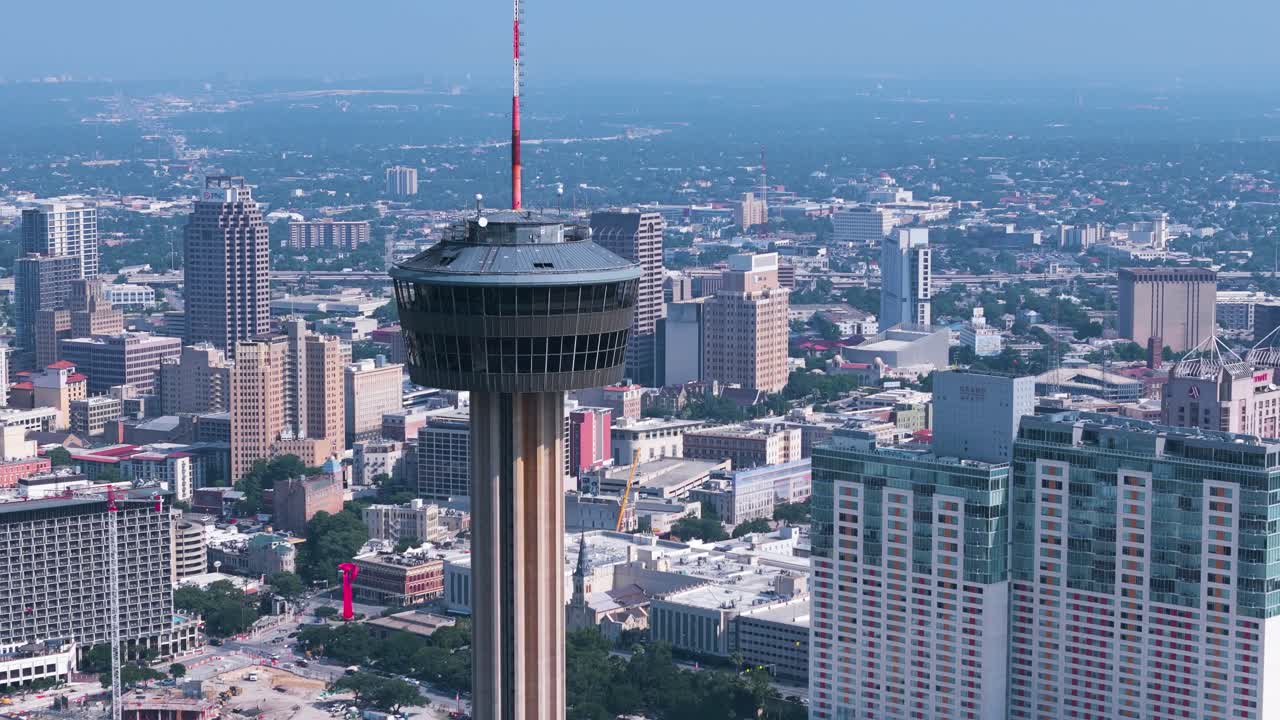 The Hemisfair Tower, also known as the Tower of Americas, sits in the heart of downtown San Antonio Texas surrounded by tall buildings, crowded highways and bustling city life
