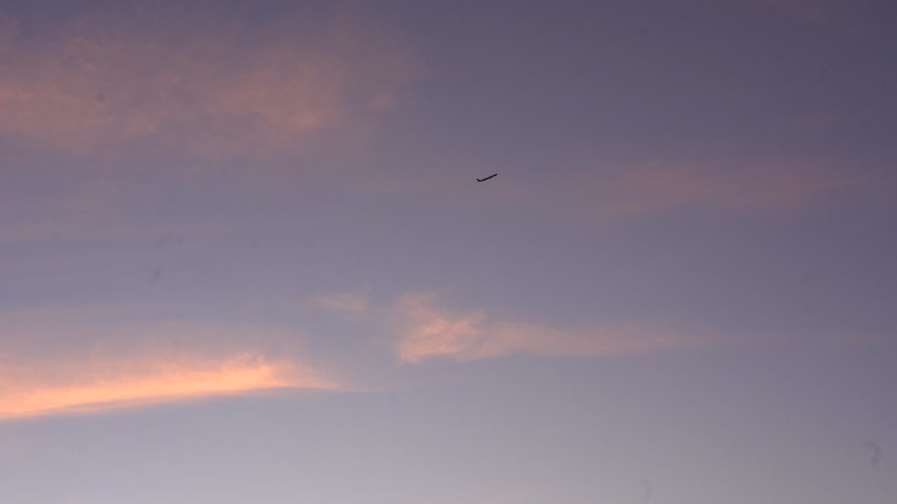 Airplane Flying through the clouds at sunset