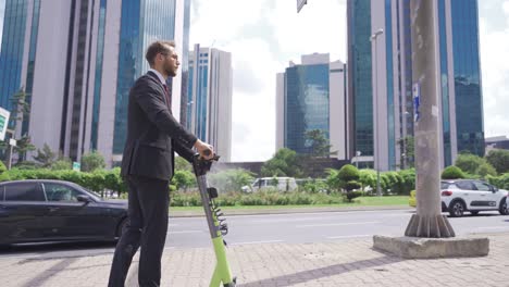 un hombre de negocios conduce un scooter eléctrico por la calle de la ciudad.