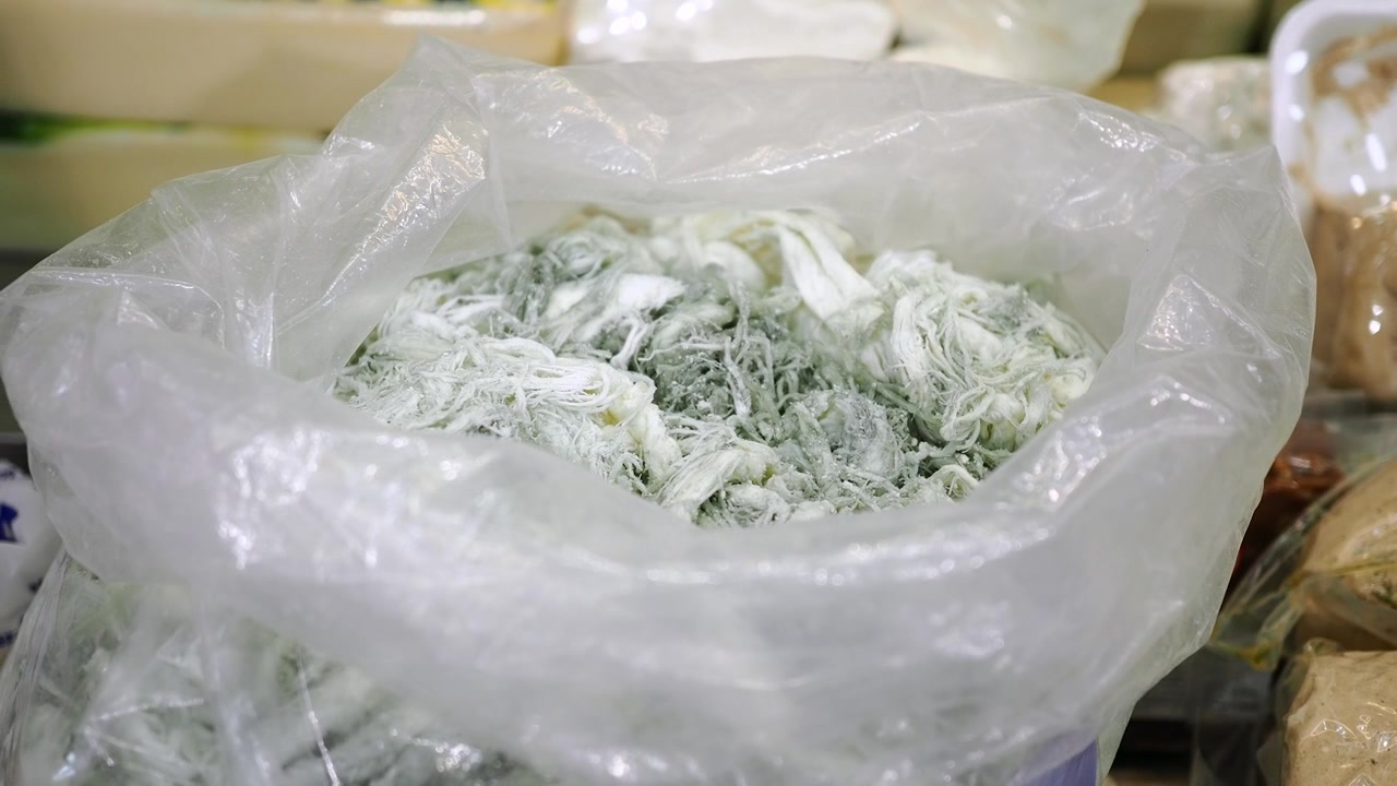 Verse geraspte kaas in plastic zak op de markt