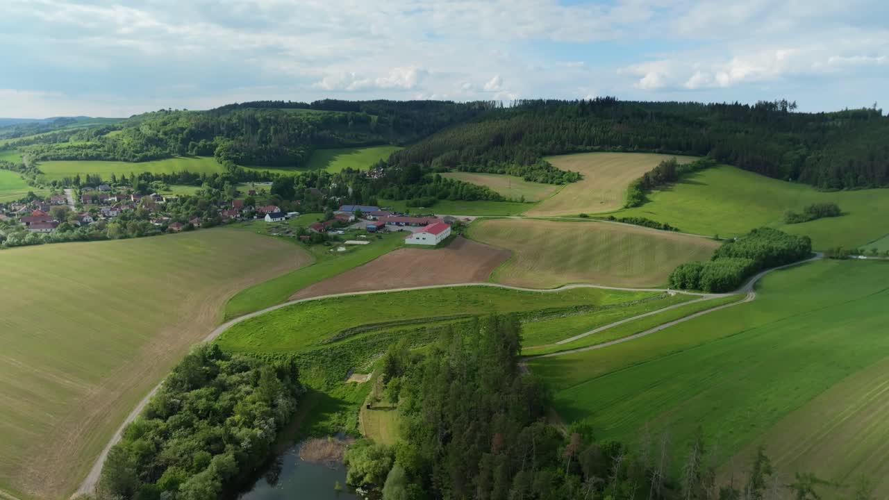 Pieni kylä ilmasta käsin luonnon vihreillä kukkuloilla. Tšekkiläinen maisema dronella kesällä.